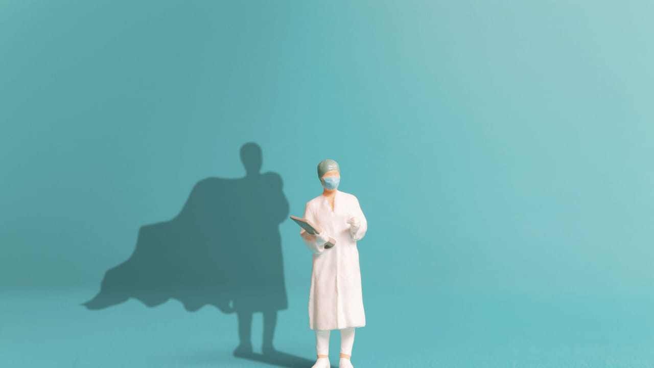 Shadowy figure of a doctor typing on laptop with AI holograms in a dark hospital corridor