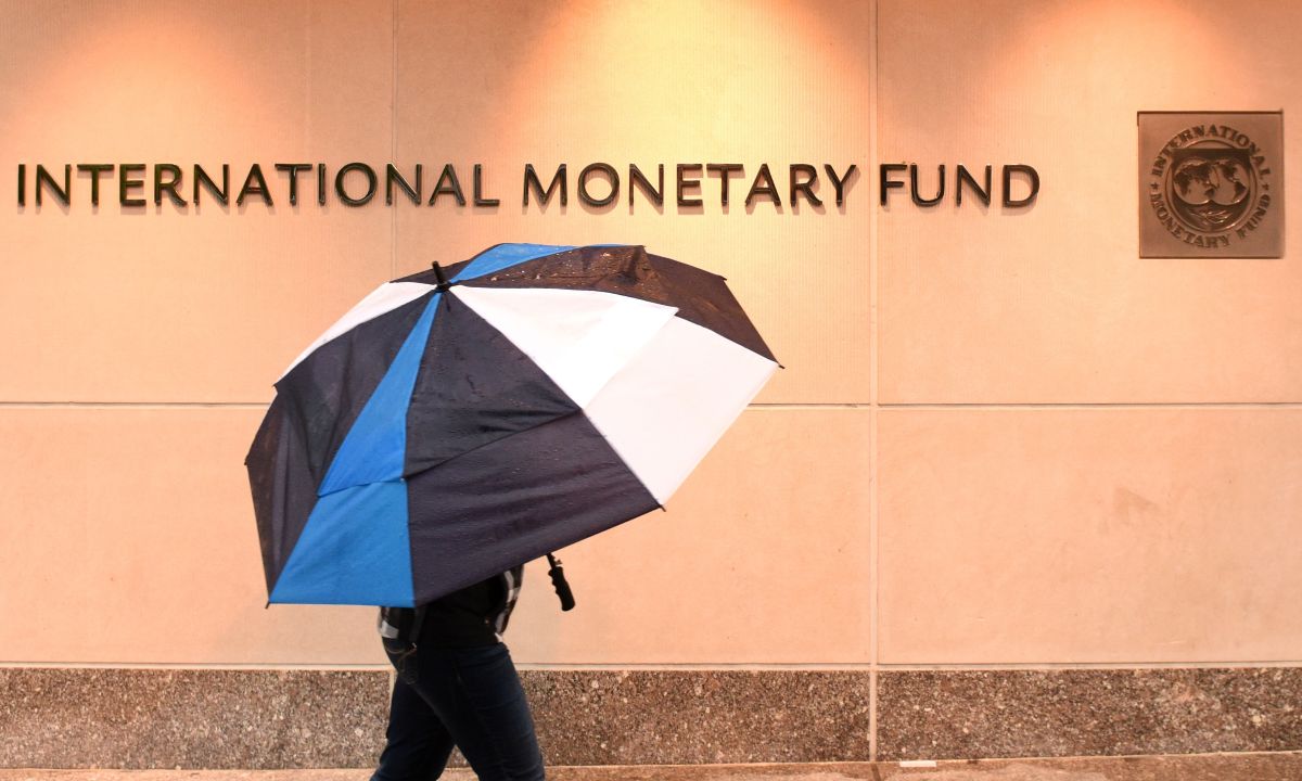 Economista del FMI revisando gráficos de riesgos de tokenización en medio de proyectos blockchain de Wall Street