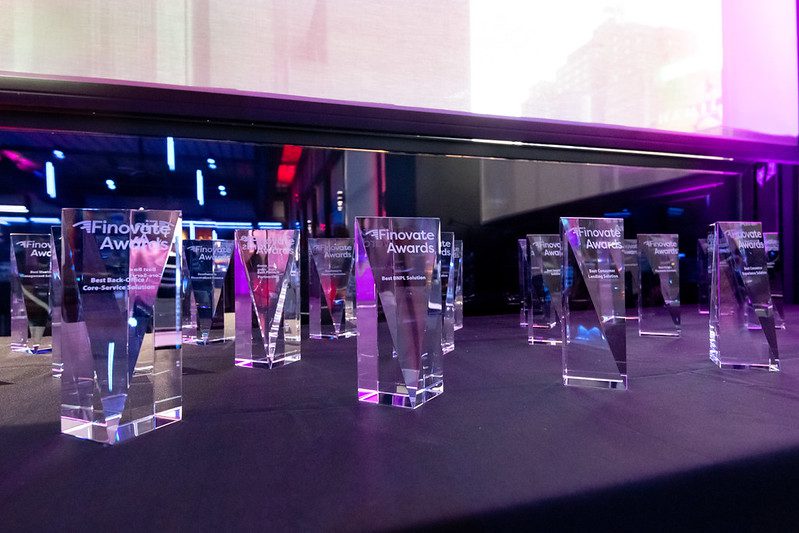 Finovate Awards stage with fintech logos and trophy under spotlight