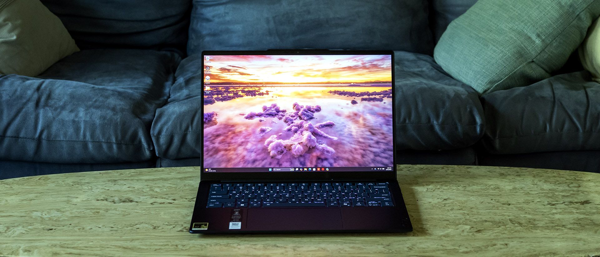 Lenovo Yoga Slim 7x laptop with a dark blue aluminum chassis shown open, displaying a vibrant OLED screen.