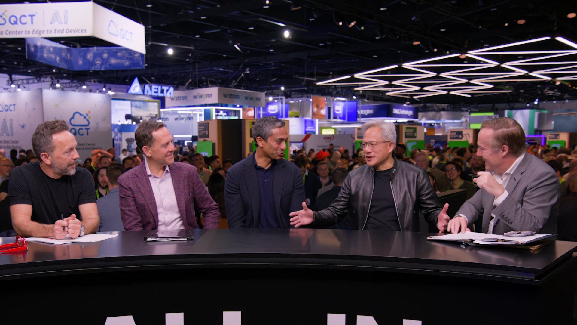 Jensen Huang in leather jacket gesturing intensely on All-In Podcast stage at Nvidia GTC