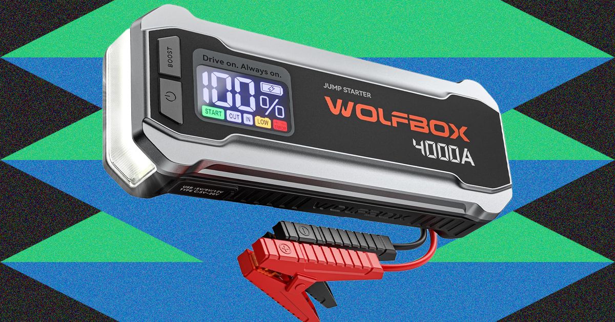 Wolfbox 4000A portable jump starter connected to a car battery under the hood