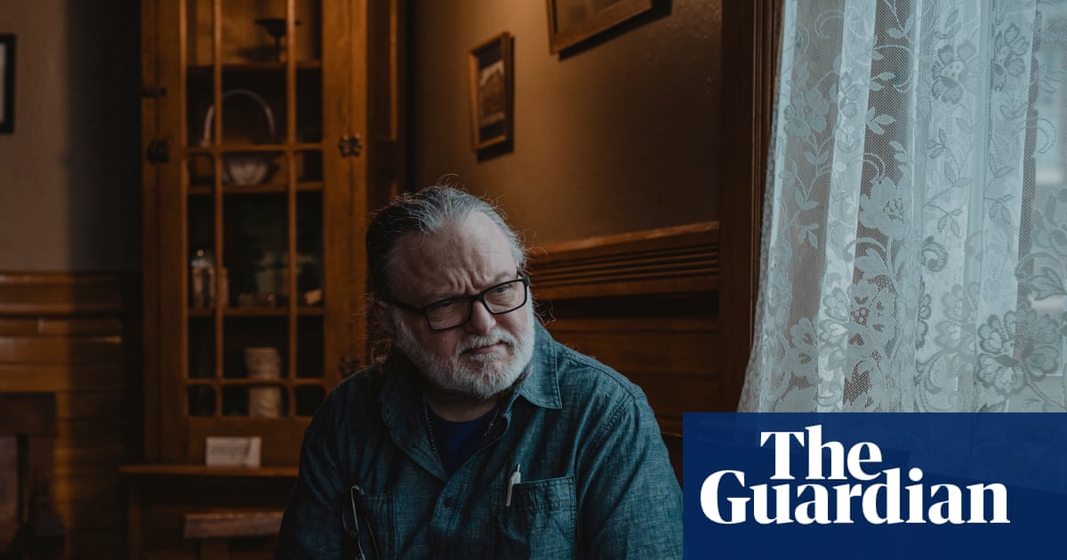 Silver-haired software engineer annotating AI data on laptop in a modest home office