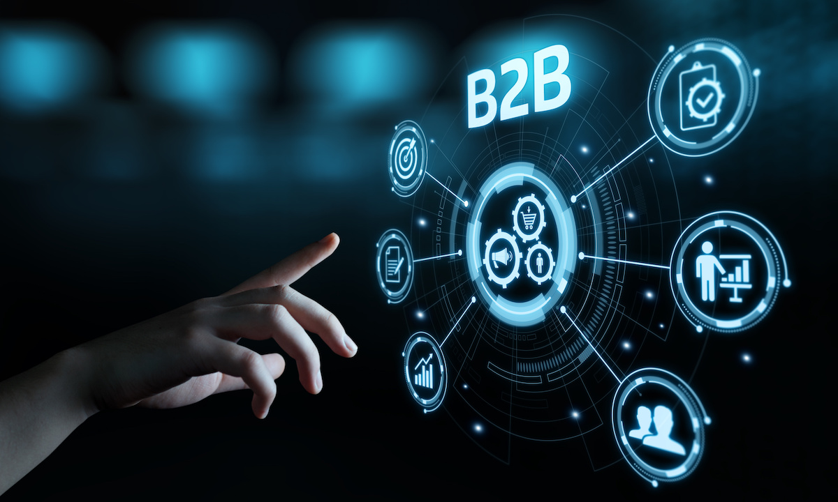 Fundador solo codando IA para compras B2B numa mesa minimalista com telas iluminadas