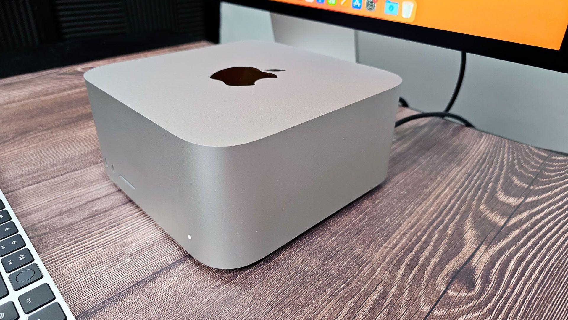 A lineup of Mac mini and Mac Studio desktop computers on a modern desk.