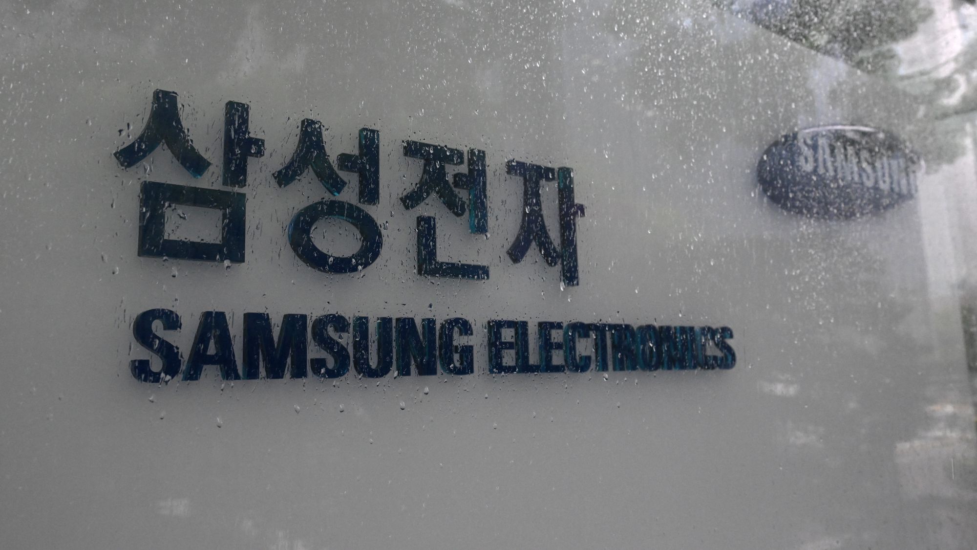 A Samsung semiconductor factory with visible production lines and workers, symbolizing the manufacturing and labor challenges.